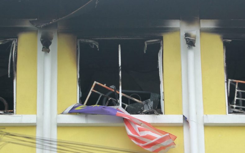 A Malaysian national flag flutters outside burnt windows of the Darul Quran Ittifaqiyah religious school in Kuala Lumpur on September 14, 2017.