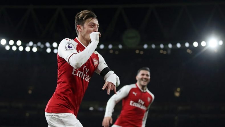 Mesut Ozil celebrates scoring the fourth goal against Huddersfield