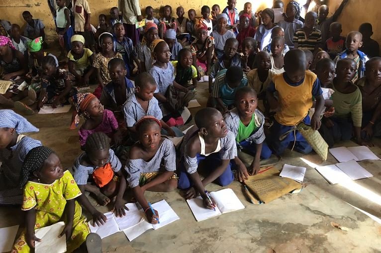 Primary school pupils studying on the floor in Kawu