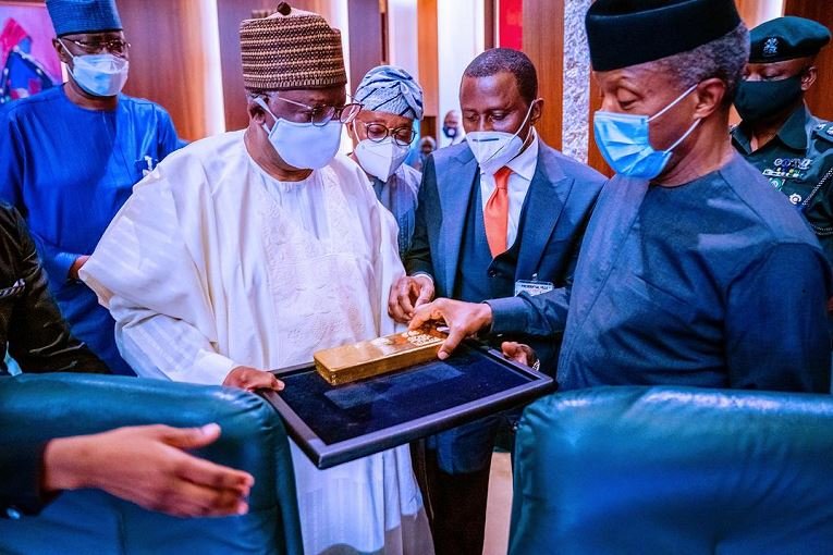 Vice President Yemi Osinbajo examines a bar of gold