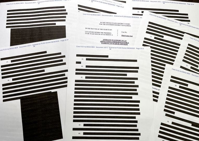 Pages of entirely redacted information are seen in the released version of an affidavit from the US Justice Department