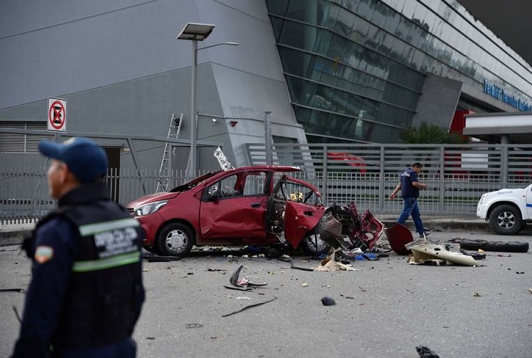 Police stand next to a car that exploded near the bus terminal in response to ongoing prisoner transfers done as part of a government plan to reduce overcrowding in the country's prisons, in Pascuales, on the outskirts of Guayaquil, Ecuador