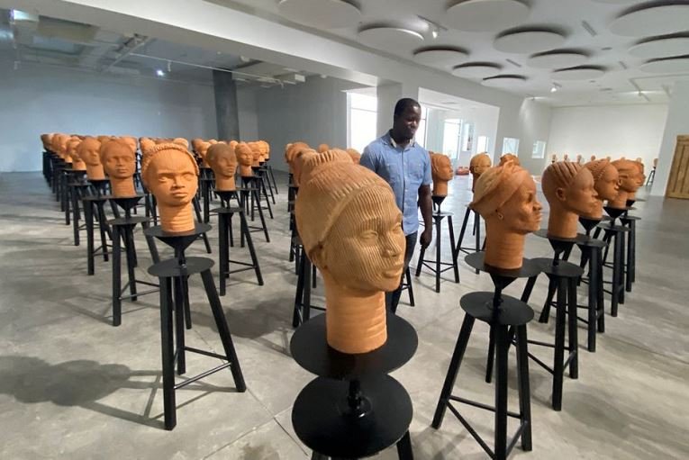 A man walks across a set up of terra cotta heads, a French woman collection representing the remaining Chibok school girls in captivity in Lagos, Nigeria, November 29, 2022 REUTERS/Seun Sanni