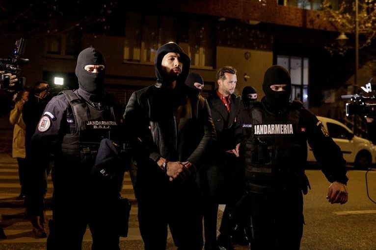 Romania asks to detain Andrew Tate for 30 days in human trafficking case Andrew Tate and Tristan Tate are escorted by police officers