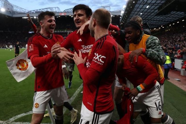 Manchester United players celebrate with Amad Diallo after he scored the winner