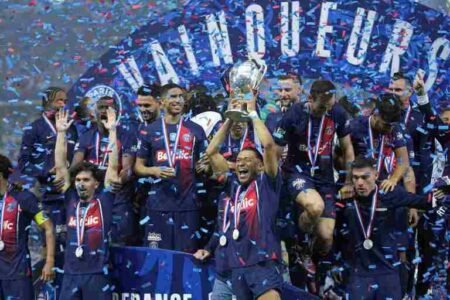 Kylian Mbappe raises the trophy to celebrate with his PSG teammates