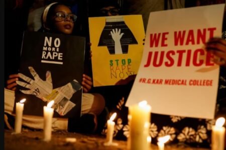 People hold posters during a vigil condemning the rape and murder of a trainee medic at a government-run hospital in Kolkata, on a street in Mumbai, India, August 14, 2024. REUTERS