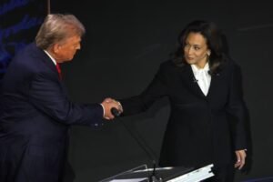 Vice President Kamala Harris walk up to former president Donald Trump to shake his hand