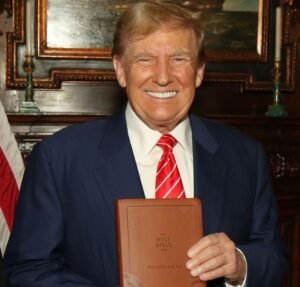 Donald Trump holding up a God Bless the USA Bible that was printed in China for $3