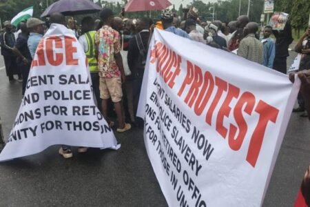 Retired police officers protest under rain at NASS gate