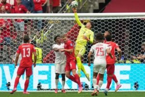 Switzerland goalkeeper Gregor Kobel leaping to block a shot during a World Cup Group B match against Canada in Vancouver