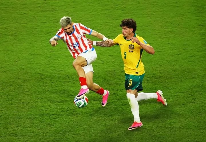 Australia's Jordan Bos challenges Paraguay's Julio Enciso during the goalless FIFA World Cup Group D match