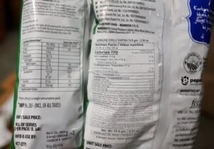 Maharashtra FDA official displays Kurkure packets with erased expiry dates and altered nutrition labels during Mumbai warehouse raid